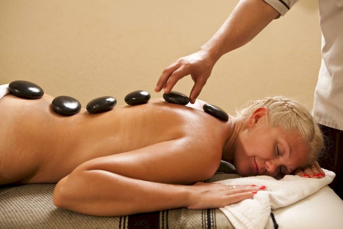 Eine Frau im Hotel Lella Baya & Thalasso genießt eine entspannende Steinmassage.