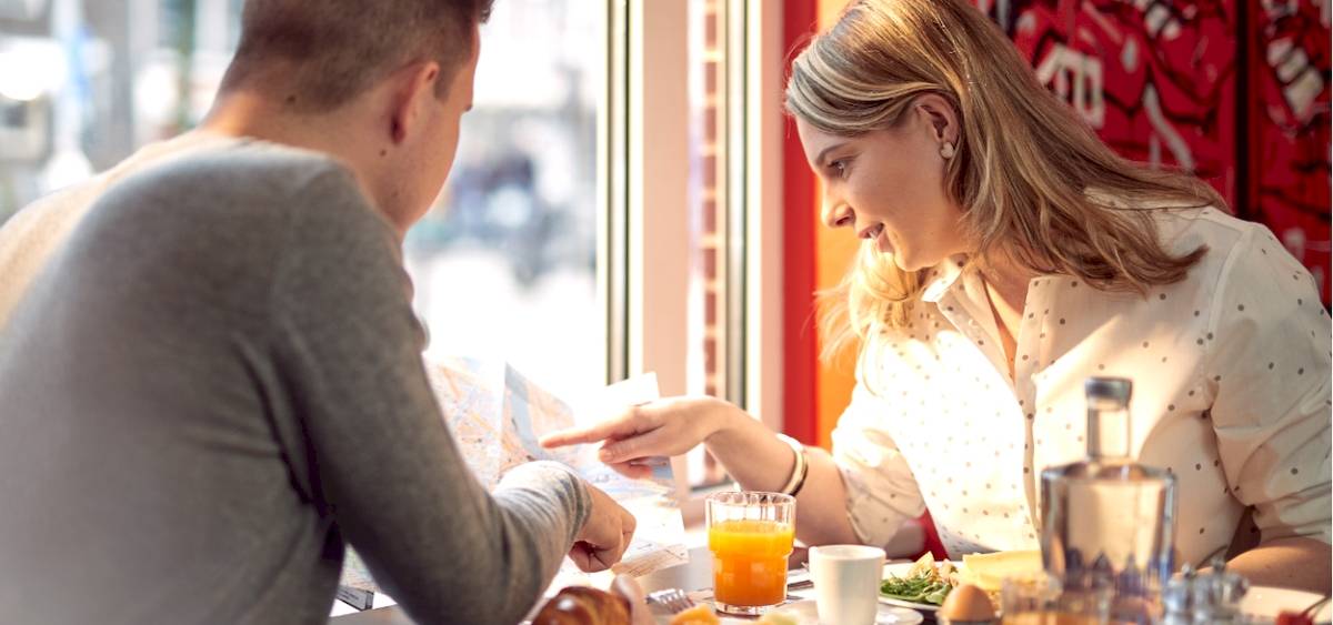 Ein Mann und eine Frau frühstücken im WestCord City Centre Hotel.