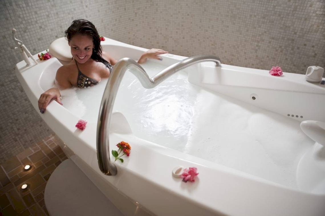 Frau in einer Badewanne im Lella Baya & Thalasso Hotel mit Blumen und Lächeln