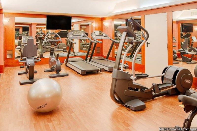 Fitnessraum im NH Roma Villa Carpegna mit Laufbändern, Hanteln und Trainingsball.