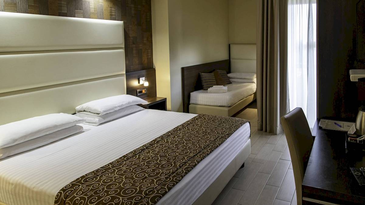 Doppelbettzimmer im Pineta Palace Hotel mit bequemen Betten und Nachttischen
