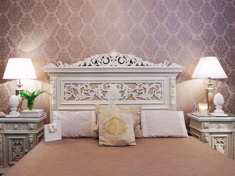 Metropole Hotel Schlafzimmer mit kunstvollen Bettkopfteil und Dekoration.