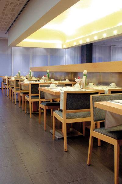 Innenansicht des Restaurants des Vincci Maritimo Hotels mit gedeckten Tischen und Stühlen.