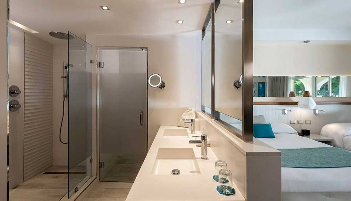 Hotelbadezimmer mit einer Dusche und einem Doppelwaschbecken.