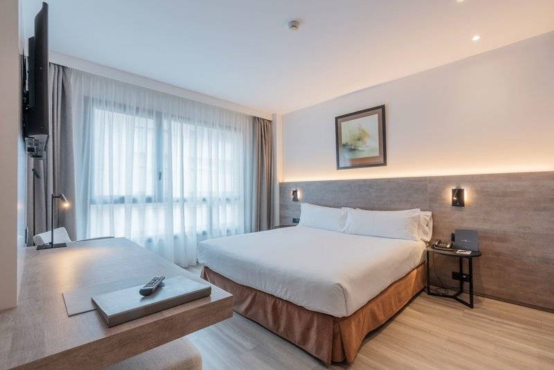 Hotelzimmer im Attica 21 Barcelona Mar mit Bett, Schreibtisch, Fernseher und Lampe.
