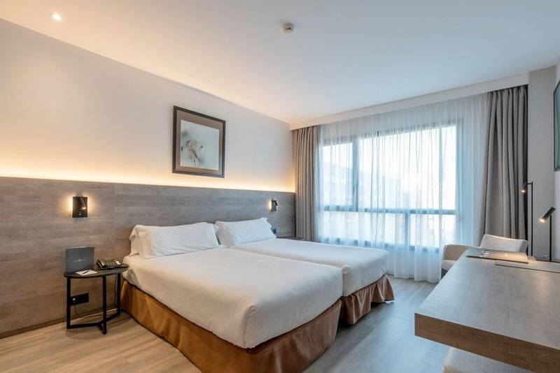 Zimmer im Attica 21 Barcelona Mar mit zwei Betten, Schreibtisch und großem Fenster.