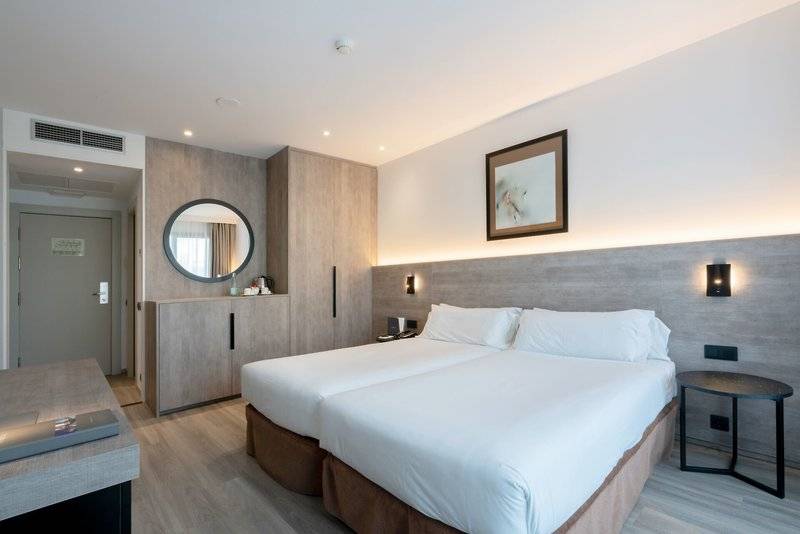 Doppelbettzimmer im Attica 21 Barcelona Mar Hotel mit moderner Einrichtung und Blick auf eine Spiegelwand.