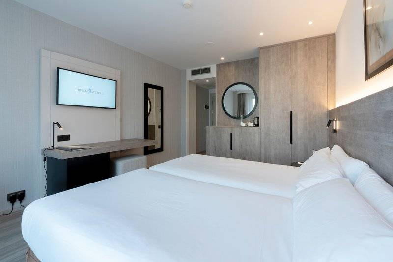 Ein Schlafzimmer im Attica 21 Barcelona Mar Hotel mit zwei Betten, einem Fernseher und einem Schreibtisch.
