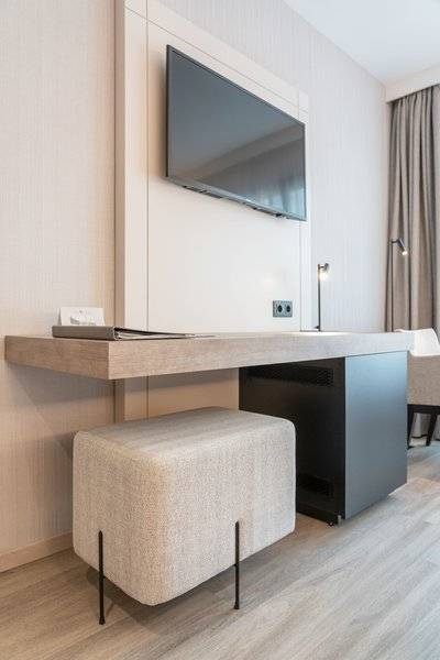 Ein modernes Zimmer mit einem Schreibtisch und Fernseher an der Wand im Attica 21 Barcelona Mar Hotel.