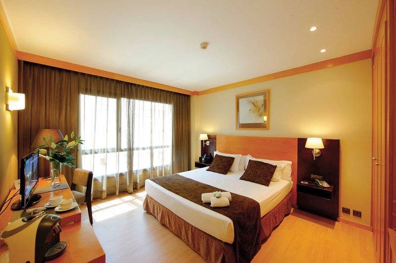 Innenansicht eines Zimmers im Hotel Attica 21 Barcelona Mar mit Bett, Schreibtisch und Fenstern.