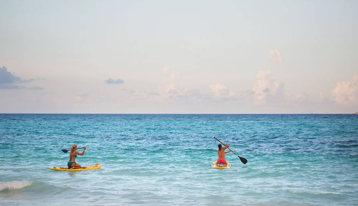 Zwei Personen auf Stand-Up-Paddleboards im Meer vor dem Catalonia Bayahibe Hotel.