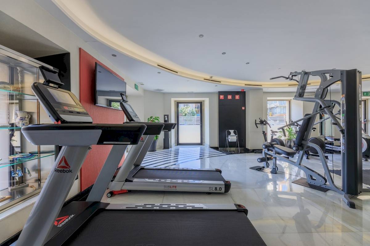 Fitnessbereich im Ciutadella Barcelona Hotel mit zwei Laufbändern und Kraftgeräten.
