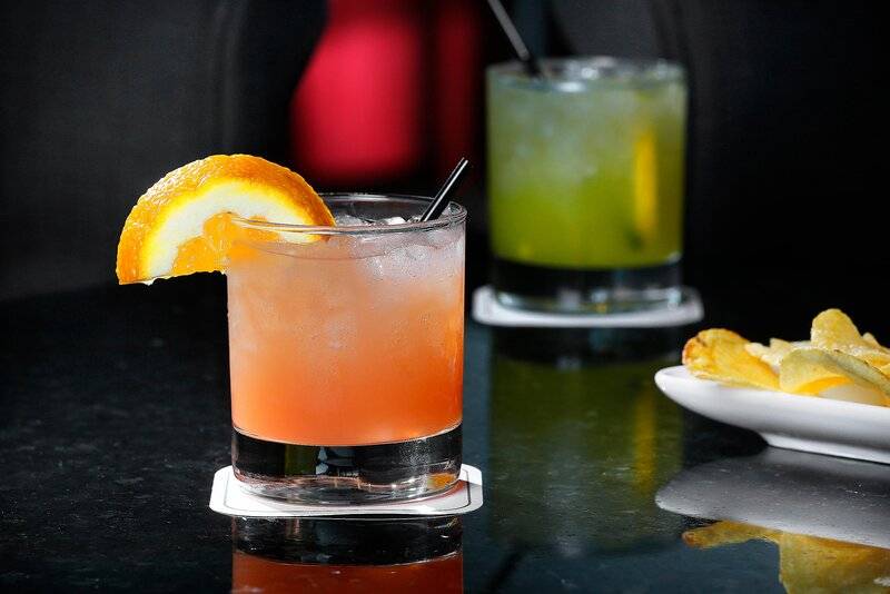 Cocktail auf einem Tisch im HCC St. Moritz Hotel mit einem grünen Getränk im Hintergrund.