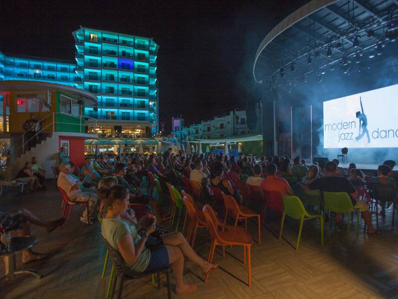 Nachtshow vor dem Azura Deluxe Resort & Spa Hotel mit vielen Besuchern auf Stühlen.