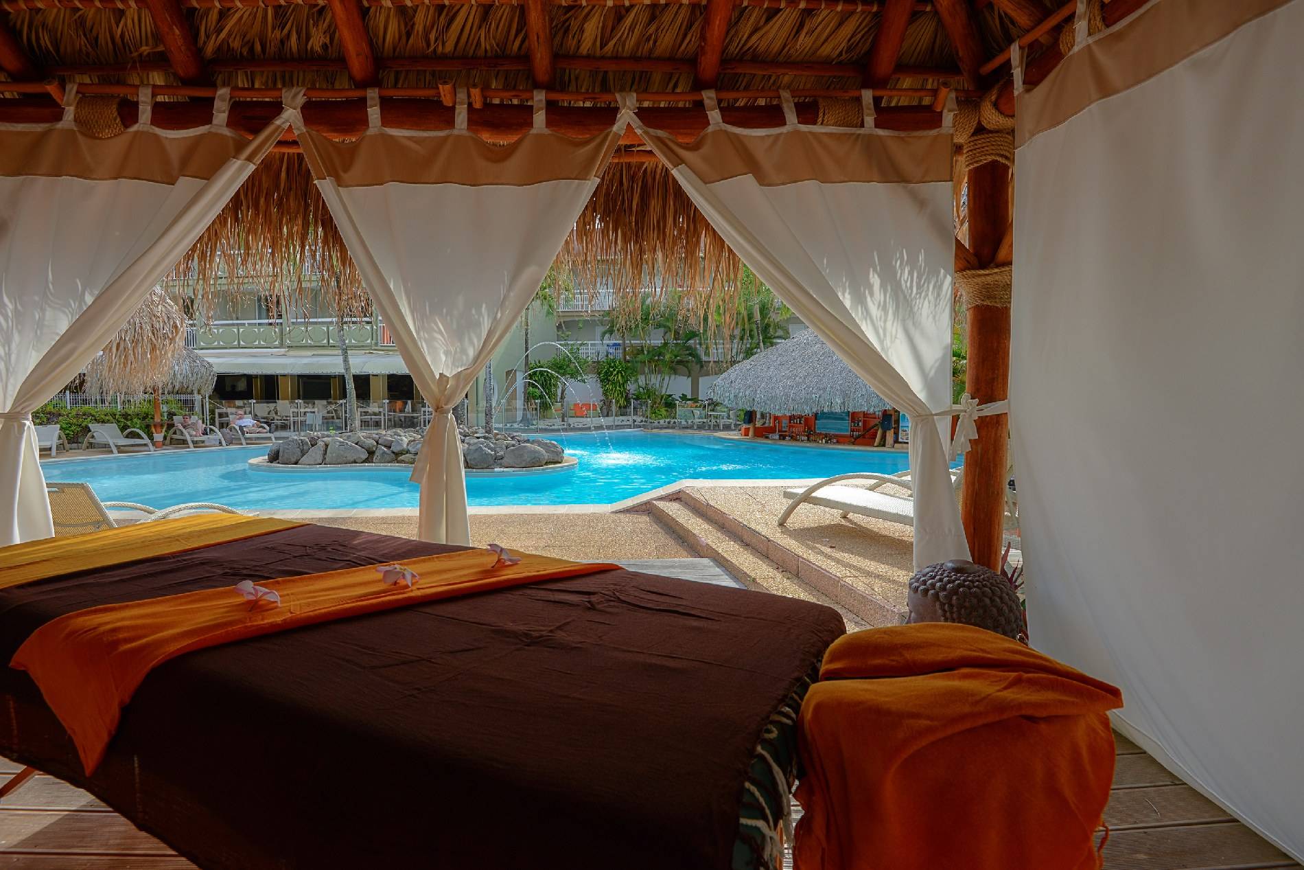 Massagebett im La Pagerie - Tropical Garden Hotel mit Blick auf den Pool.
