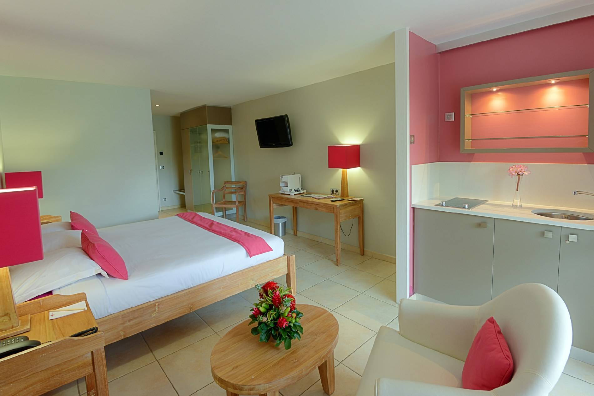 Zimmer im La Pagerie Tropical Garden Hotel mit Bett, Schreibtisch, Stuhl und Deko.