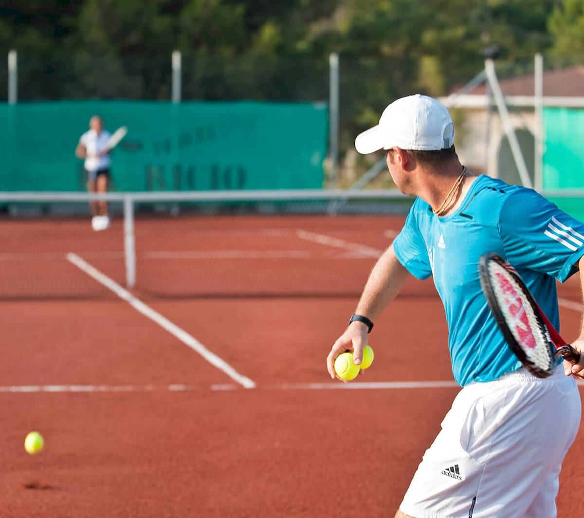 Tennisspieler spielt auf einem roten Tennisplatz während eines Matches.