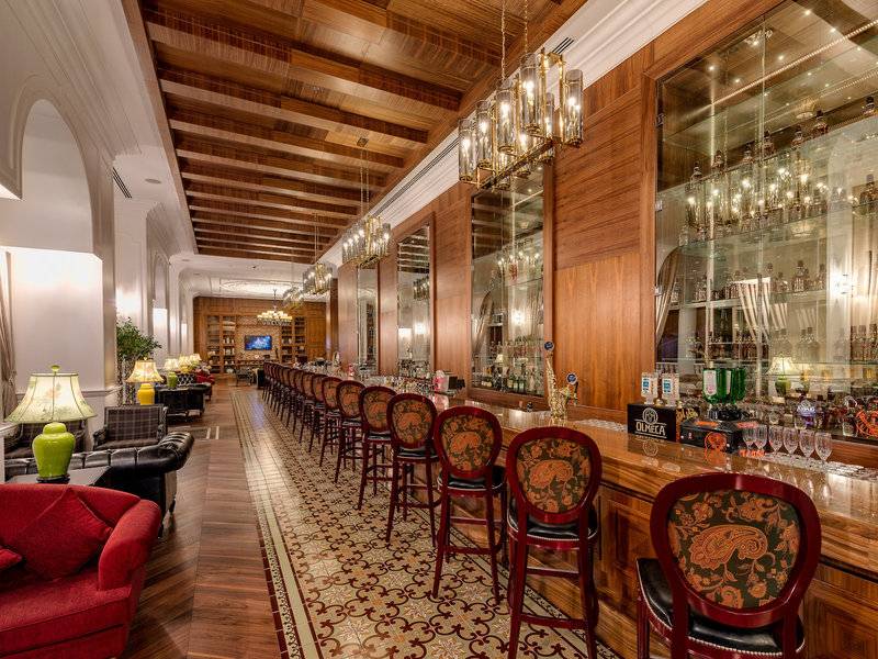 Barbereich des Rubin Platinum Spa Resorts & Suites Hotel mit Holzmöbeln und kunstvollen Stühlen