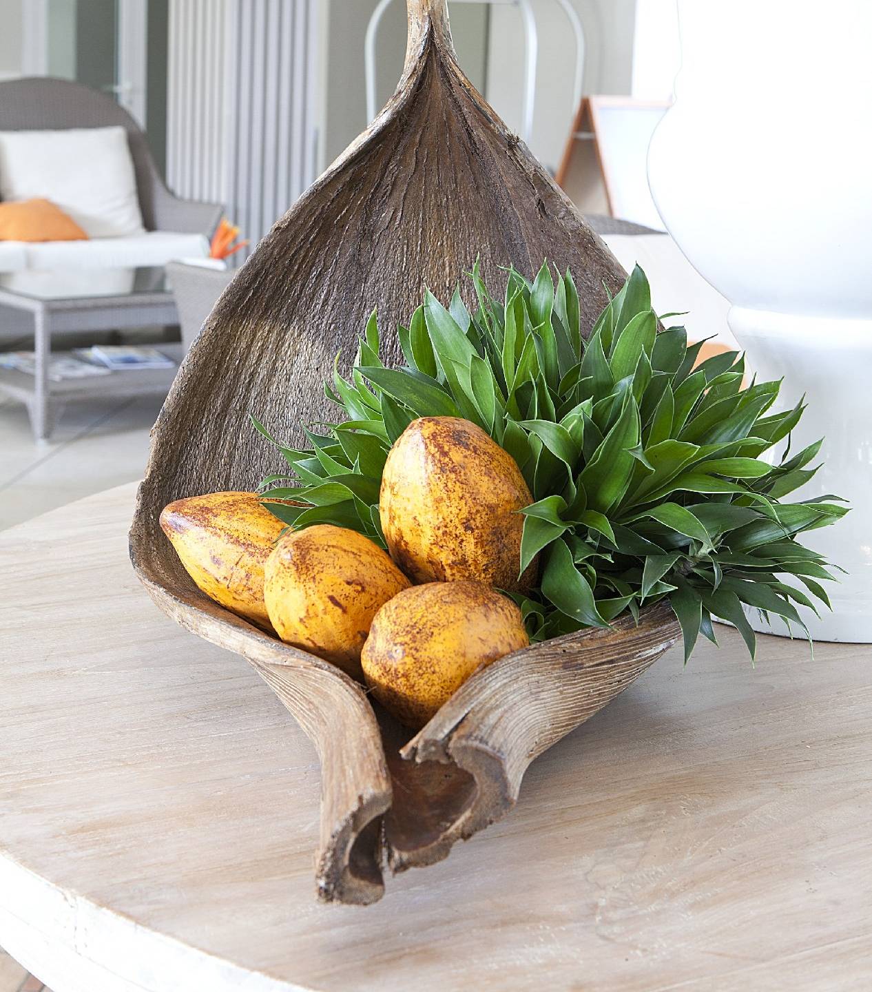 Ein Zimmer im La Pagerie - Tropical Garden Hotel mit einer großen Holzschale, die Früchte und Pflanzen enthält.