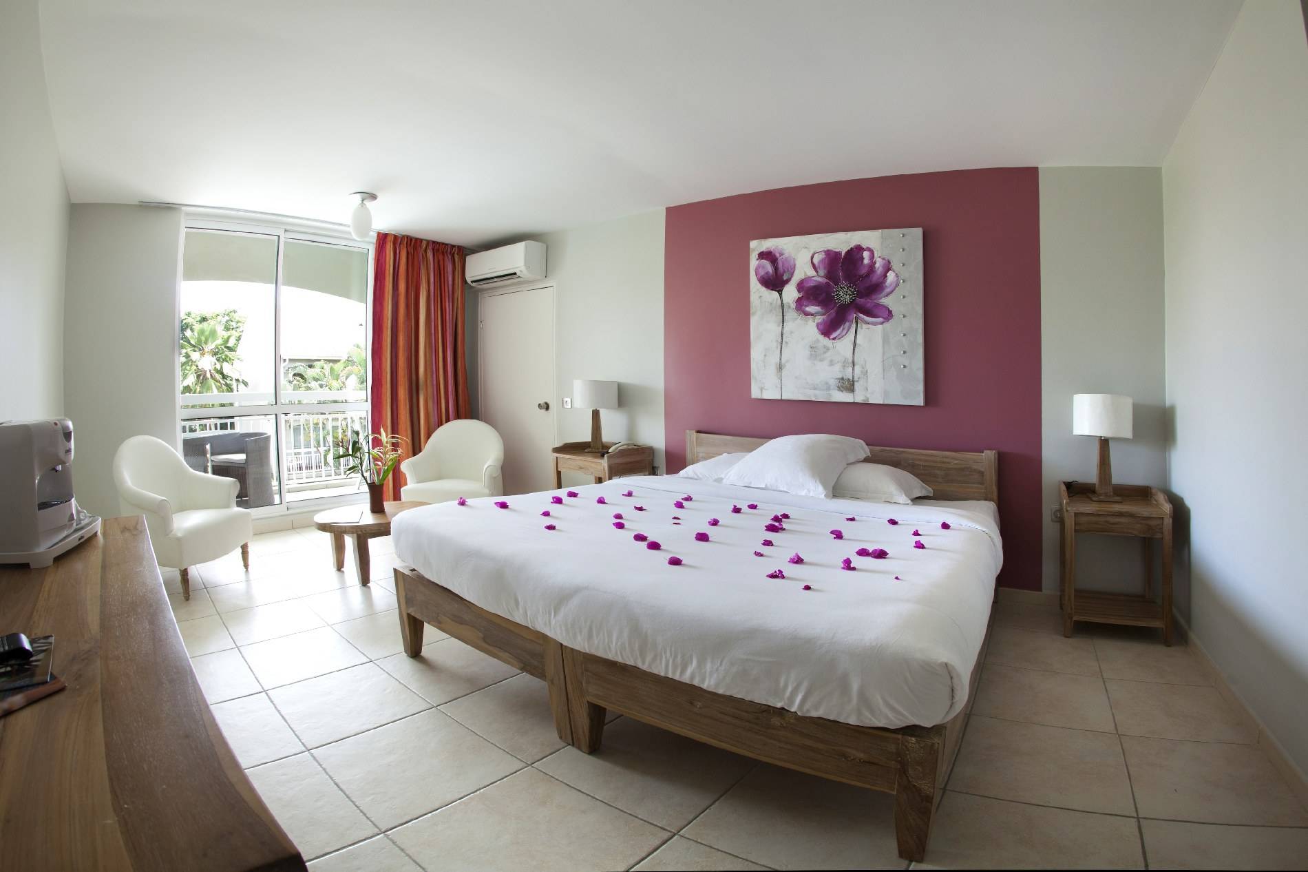 Schlafzimmer im La Pagerie - Tropical Garden Hotel mit Blumenblättern auf dem Bett