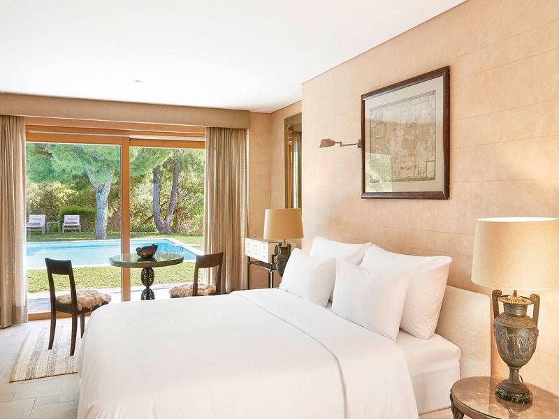 Schlafzimmer im Cape Sounio Grecotel Resort mit Blick auf den Pool und Garten