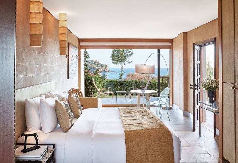 Schlafzimmer im Cape Sounio Grecotel Resort mit Blick auf das Meer und die Terrasse