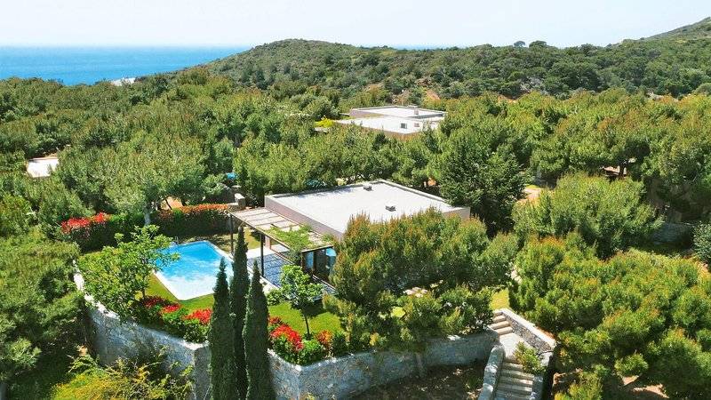 Aussenansicht des Cape Sounio Grecotel Resorts mit Swimmingpool und umliegender Natur.