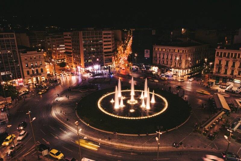 Luftaufnahme von einer großen Stadt mit Brunnen und Verkehrskreisel