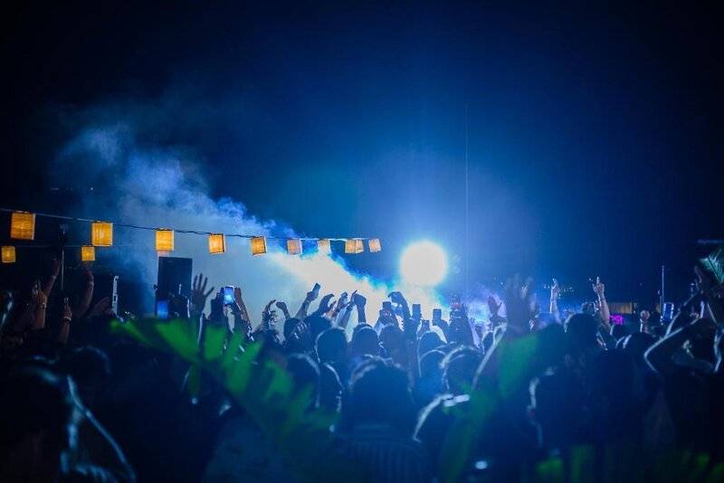 Nachtveranstaltung im Skylark, Aluma Hotel & Resort mit vielen Gästen, Lichteffekten und einer Bühne.