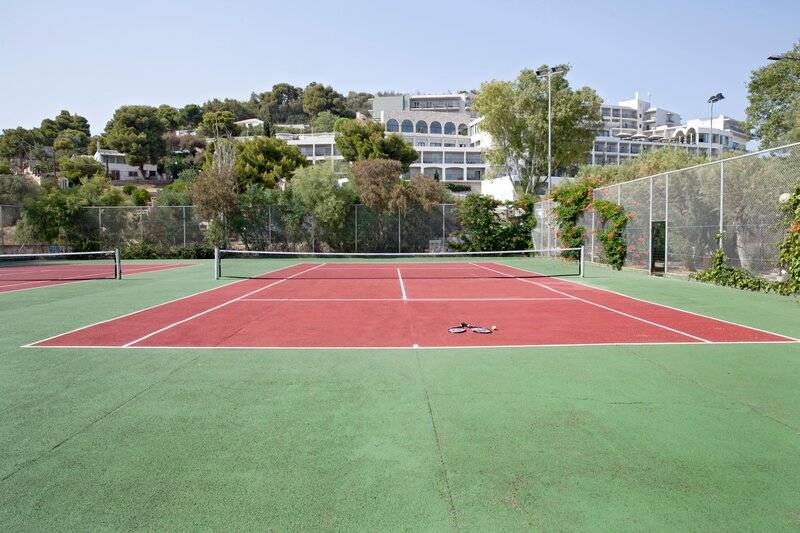Doppeltennisplatz im Dolce Athens Attica Riviera Hotel, mit grünem und rotem Belag.