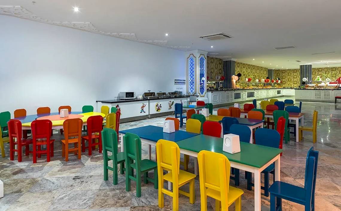 Kinderspeiseraum des Sultan of Dreams Hotels mit bunten Tischen und Stühlen.