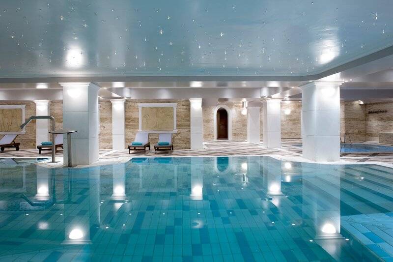 Schwimmbecken im Hotel Dolce Athens Attica Riviera mit blauen Kacheln und weißen Säulen
