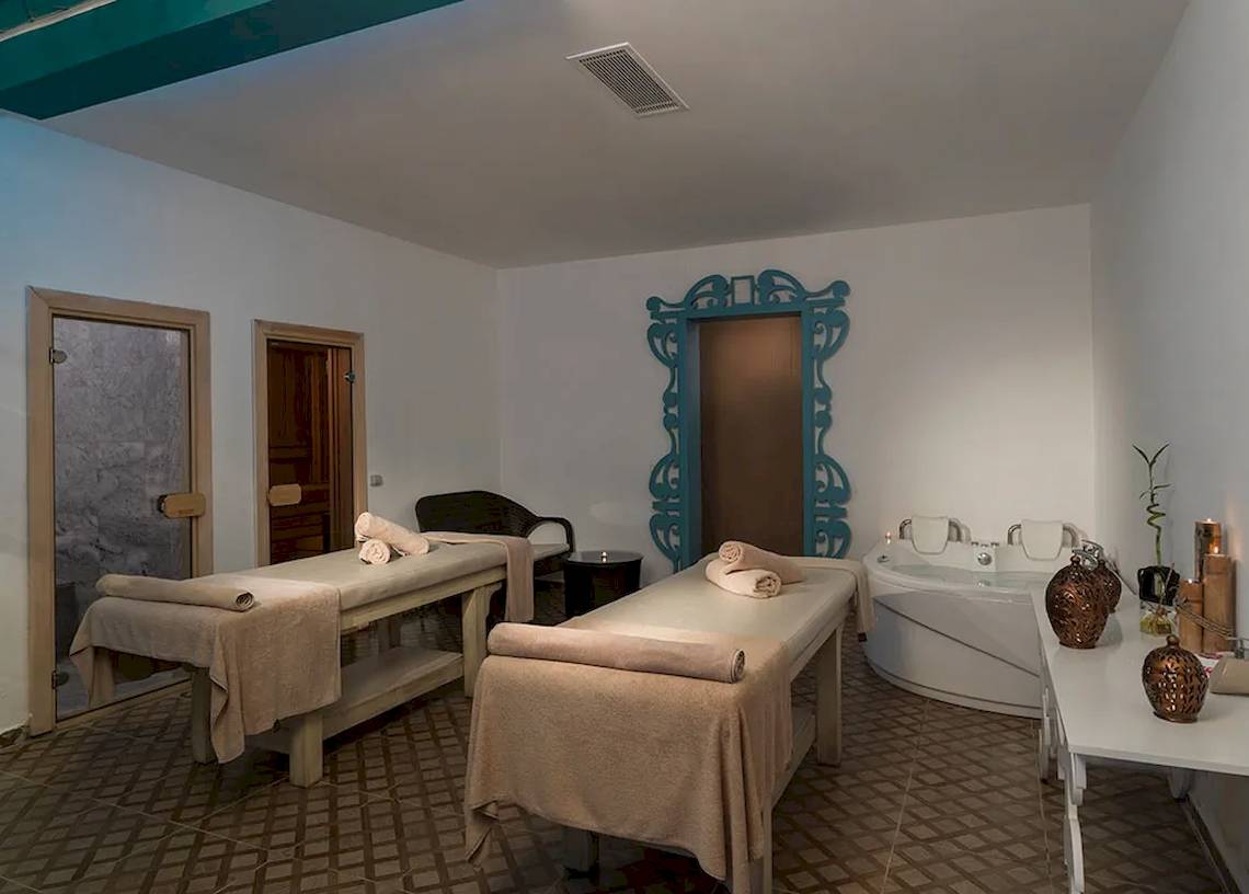 Spa-Behandlungszimmer im Sultan of Dreams Hotel mit zwei Massagetischen und einer Badewanne.