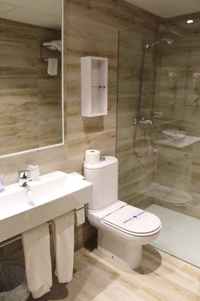 Badezimmer des R2 Veronica Beach Hotel mit einer Dusche, Toilette und Waschbecken.
