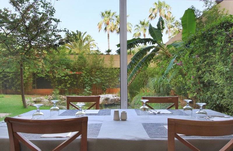 Esstisch im Garten des Bakour Garbi Cala Millor mit Blick auf eine gepflegte Landschaft.