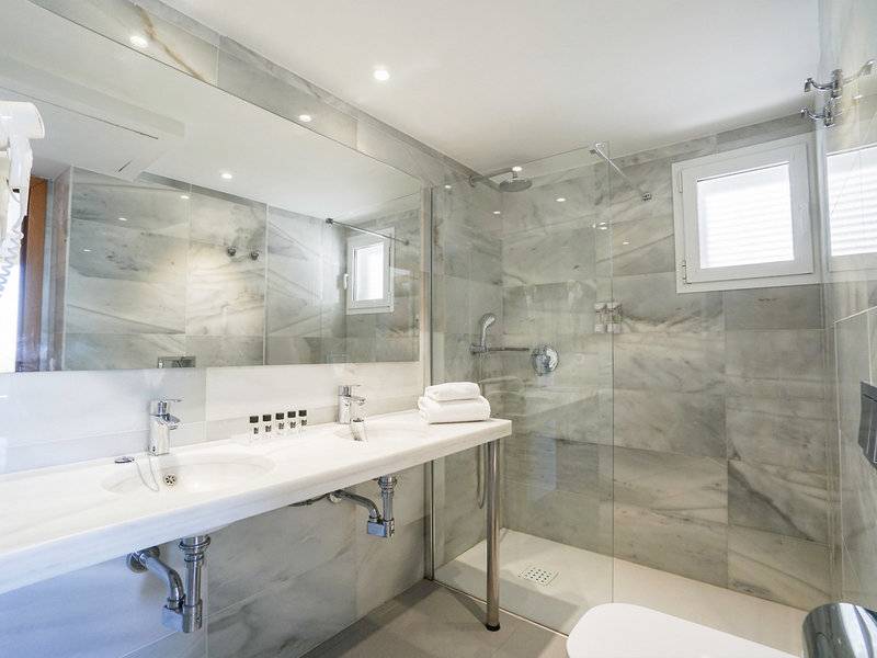Badezimmer des Millor Sol Hotels mit Doppelwaschbecken, Dusche und Toilette