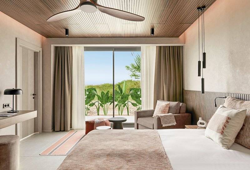 Schlafzimmer im Aldiana Club Side Beach Hotel mit großem Bett, Fenster und Aussicht auf die Natur.