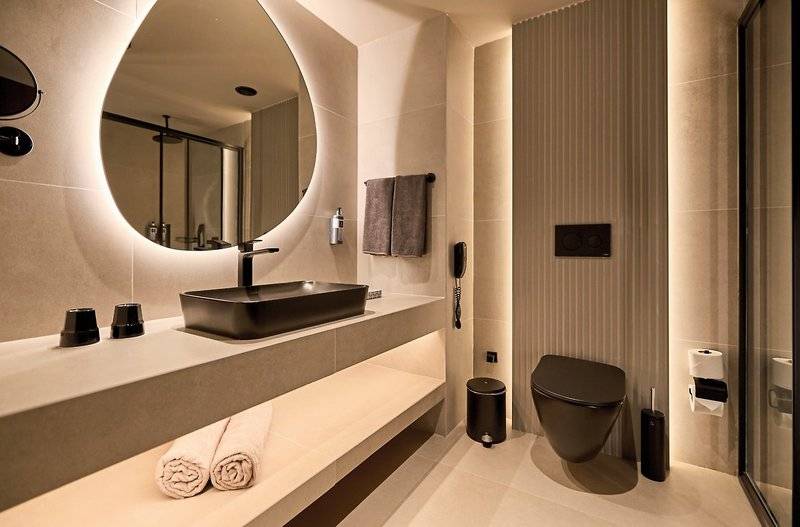 Badezimmer im Aldiana Club Side Beach mit runden Spiegel und luxuriöse Ausstattung.