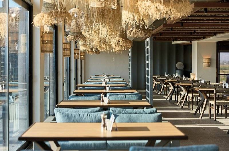 Innenansicht des Restaurants im Aldiana Club Side Beach mit blauen Stühlen und Tischen.