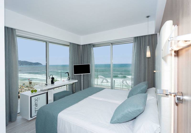 Hotelzimmer mit Meerblick am Kyrat Amarac, mit Bett, Schreibtisch und Fernseher.