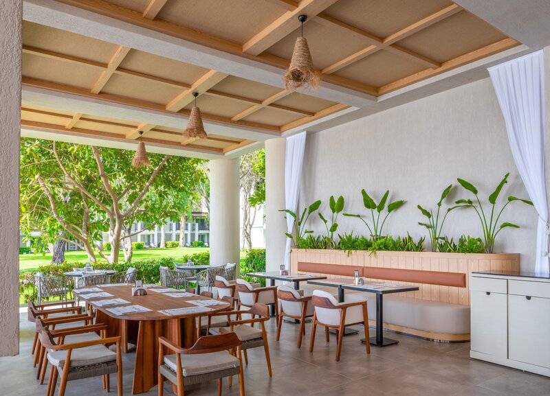 Terrassenrestaurant des Sherwood Exclusive Kemer Hotels mit Tischen, Stühlen und Pflanzen