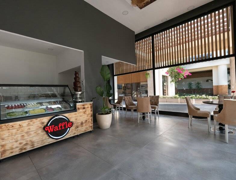 Innenansicht der Waffel Bar im Sherwood Exclusive Kemer Hotel mit einer Waffel Theke und freien Tischen