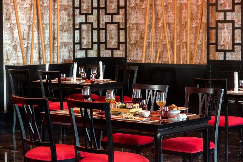 Restauranttisch im Sherwood Exclusive Kemer mit Speisen und Weingläsern.