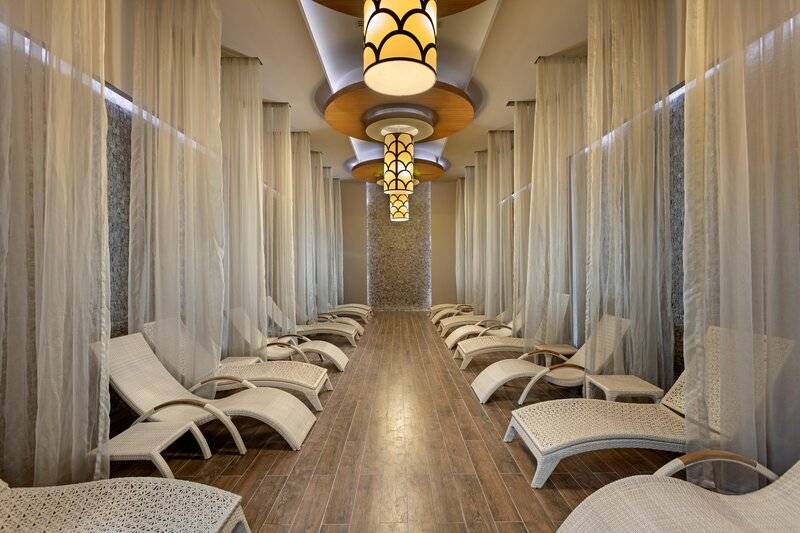 Spa-Lounge im Sherwood Exclusive Kemer Hotel mit weißen Liegestühlen und Vorhängen