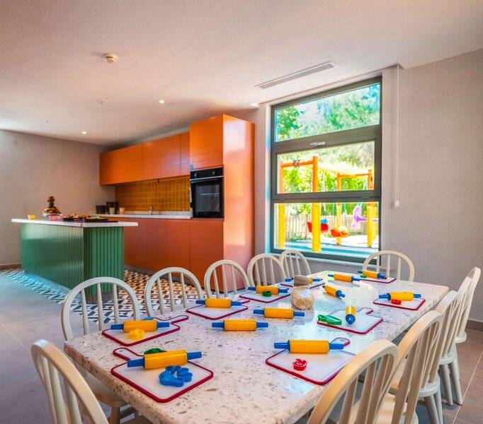 Kinder Spielzimmer im Sherwood Exclusive Kemer Hotel mit Tisch, Stühlen und Spielzeug.