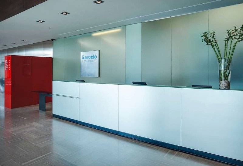 Empfangsbereich des Barcelo Valencia Hotels mit moderner Einrichtung und Barcelo Schild.