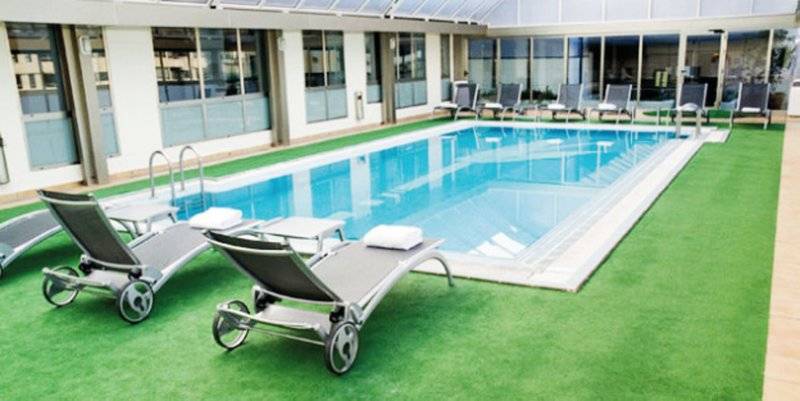 Außenpool im SH Valencia Palace Hotel mit Liegestühlen und Sonnenschirmen