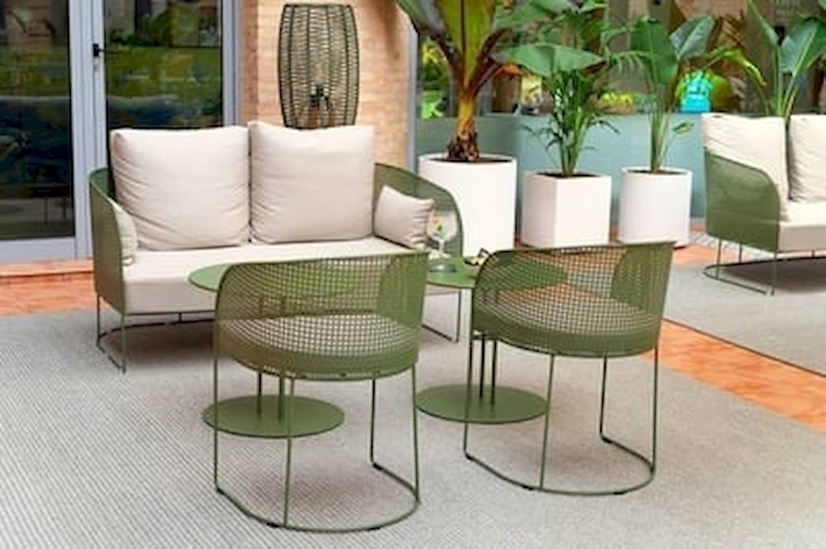 Lounge-Bereich des DWO Valencia Hotels mit grünen Möbeln und Pflanzen.