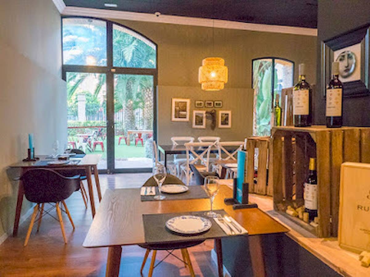 Innenbereich des DWO Valencia Restaurants mit Tisch, Stühlen und Blick auf eine Terrasse.