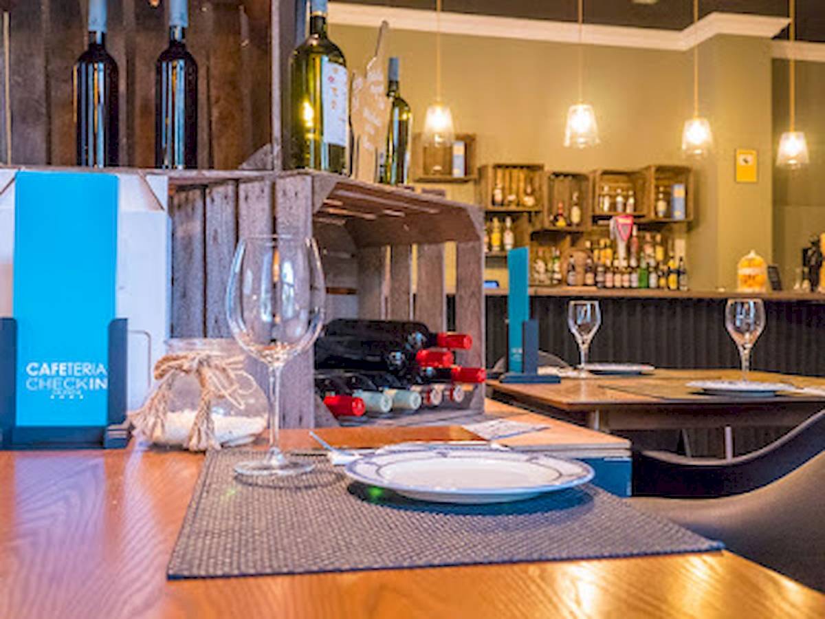 Ein Restaurantbereich des DWO Valencia Hotels mit einer Tischanordnung, Flaschen und Gläsern.